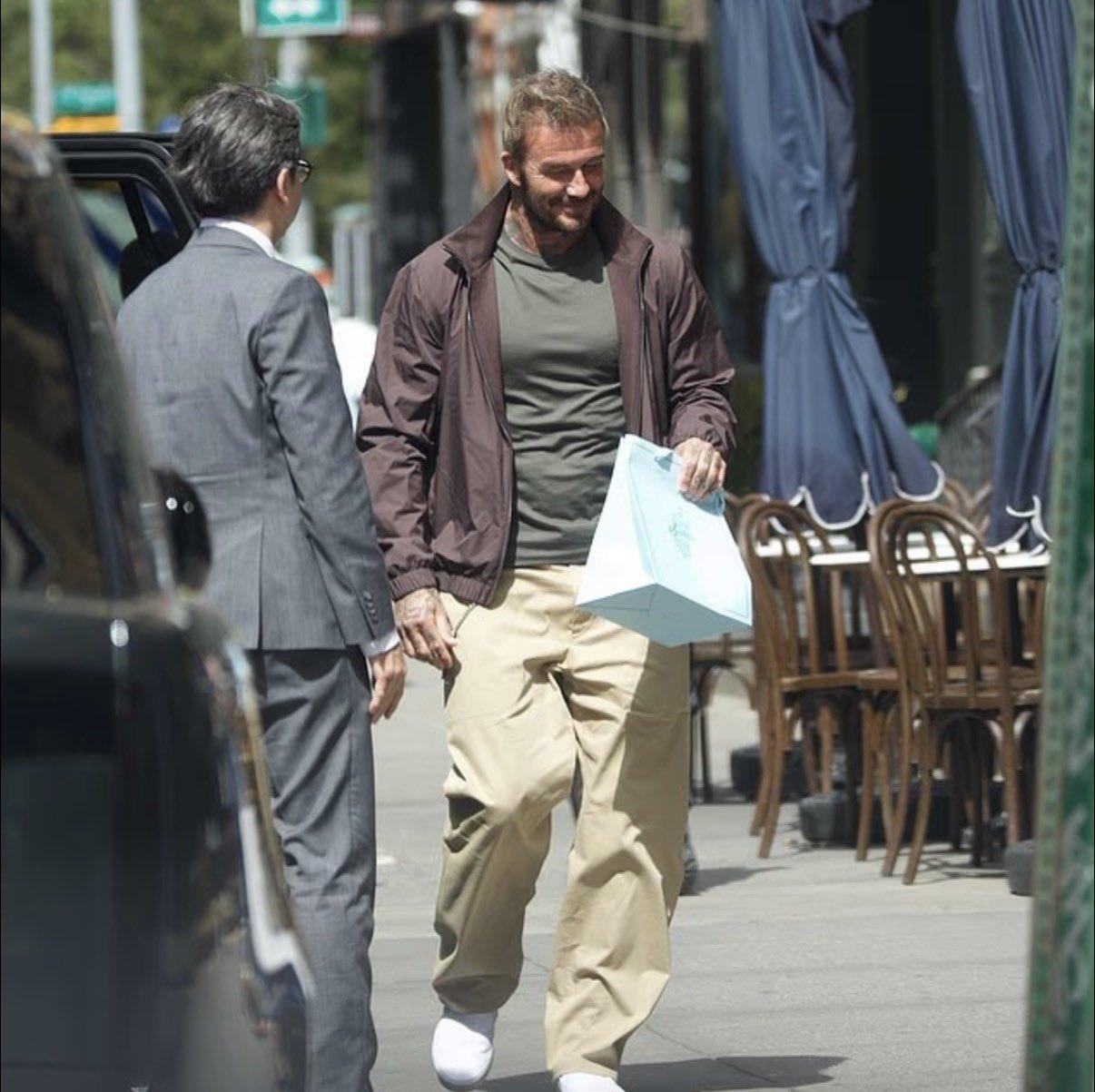 大卫·贝克汉姆搂着14岁的女儿哈珀，哈珀手里拎着一个价值3100英镑的包，两人在