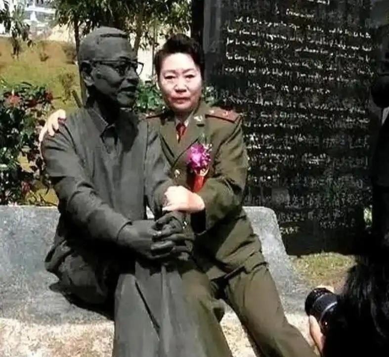 1997年，陈景润的夫人坐在丈夫的雕塑旁边，搂住“丈夫”的肩膀，留下了这张令人垂