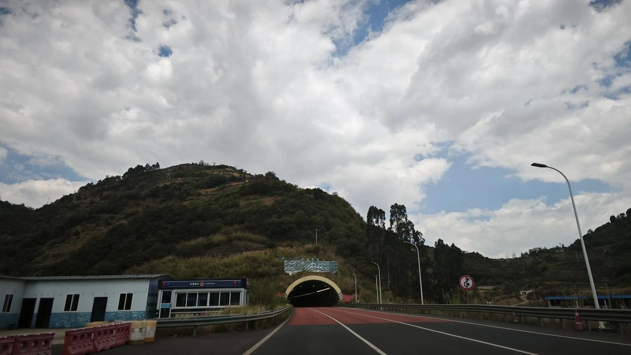 路上看到的春日街景穿过隧道，奔赴下一场山海。红与黑的公路向山腹延伸，云卷云舒间，