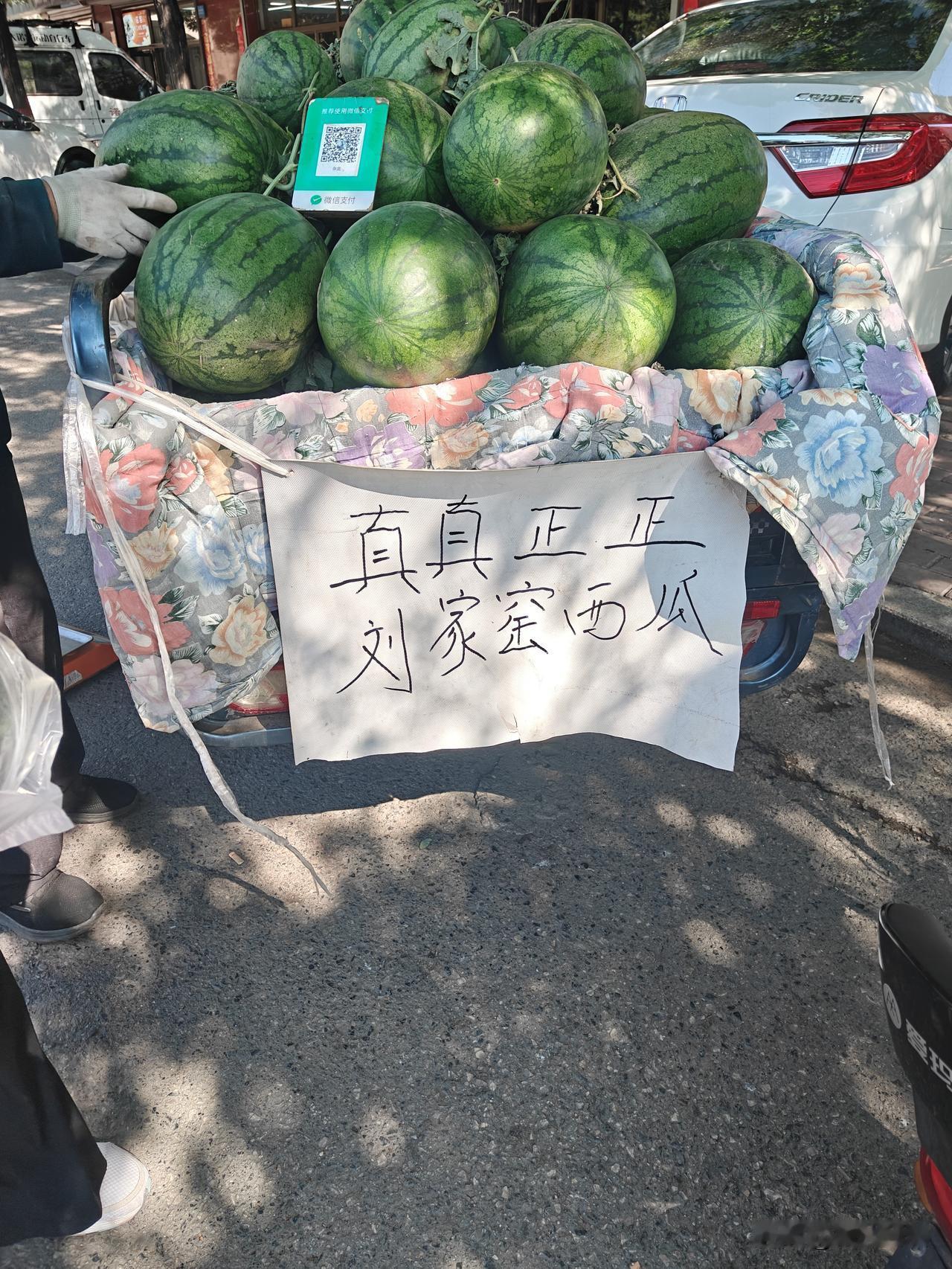 宣化刘家窑的西瓜上市啦，有个农民在农用车后边挂了个硬纸牌子，上面写着“真真正正的