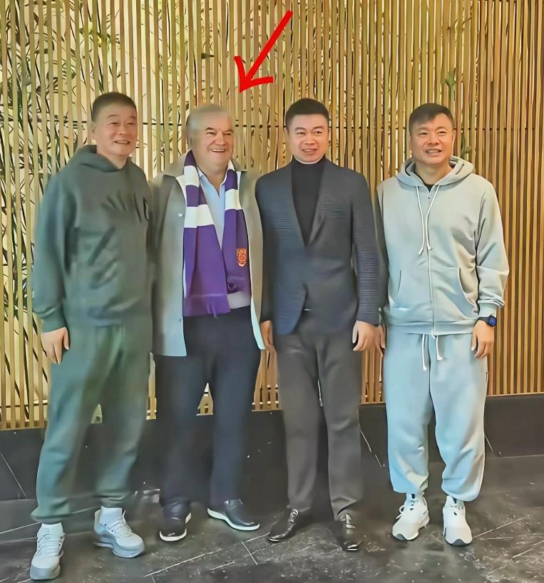 能认识于根伟指导右侧的这位洋老爷子，绝对是20年以上的老球迷。
照片中左数第二位