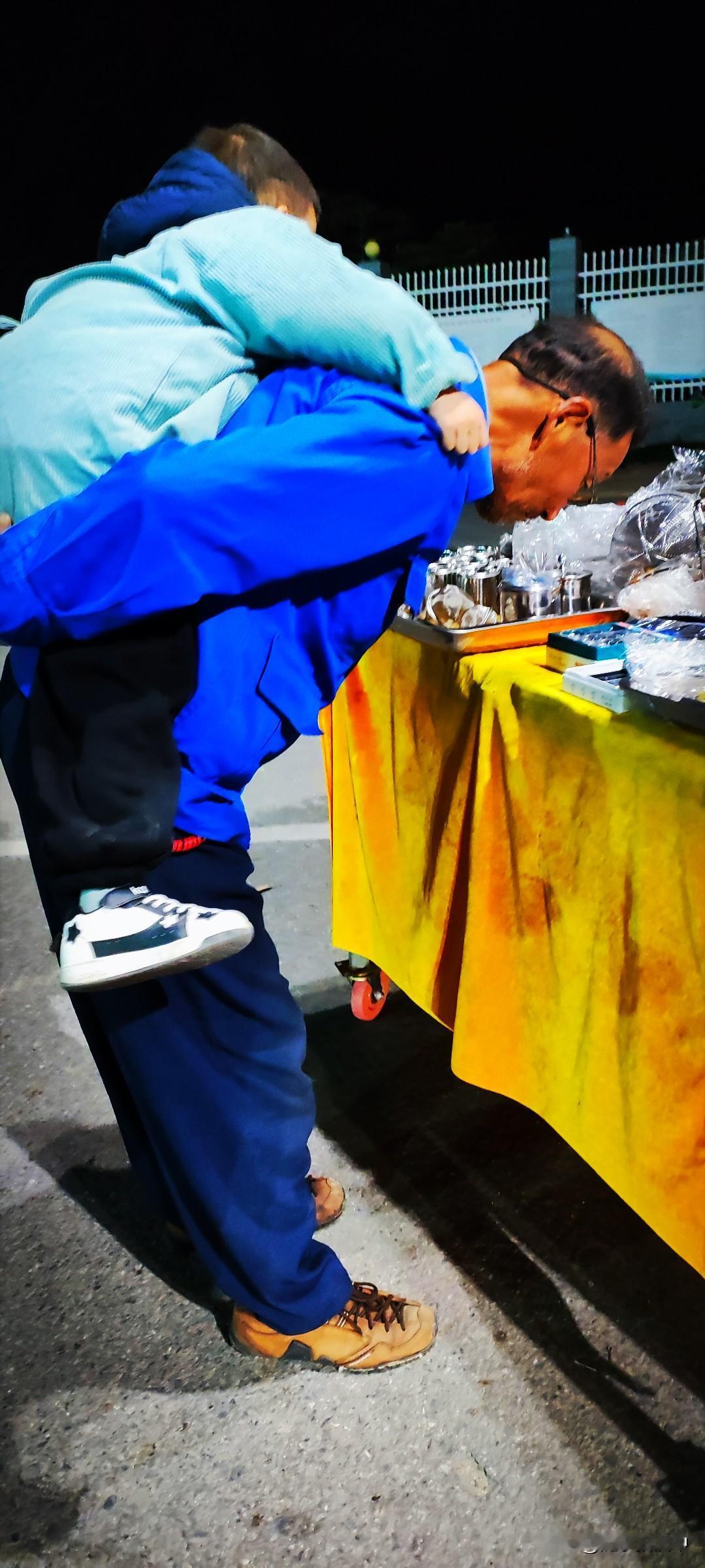 晒图笔记大赛夜晚的十字路口有摆摊的，10元5元的小东西摆放整齐。背着孙子散步的大