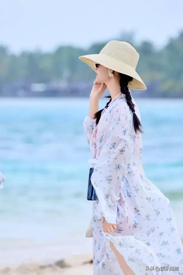近日，李沁的度假美照惊艳亮相。画面里，她身着白色碎花防晒衣，头戴一顶草帽，亭亭玉