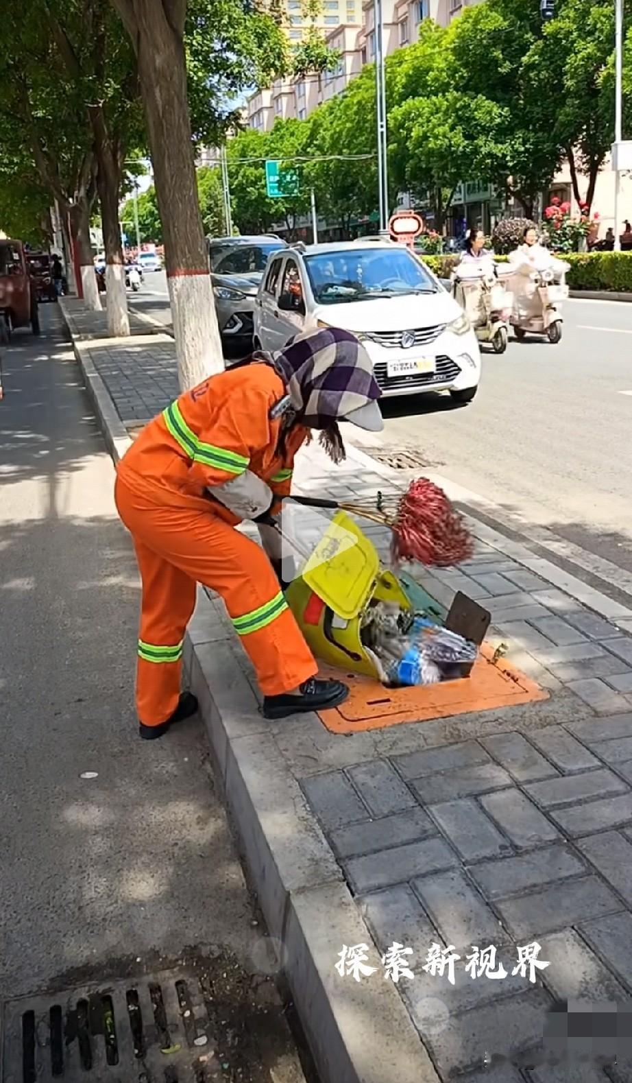 这是地下垃圾桶吗？有路人拍到有位环卫工扫完的垃圾直接倒到路边的沙井盖里面。看表面