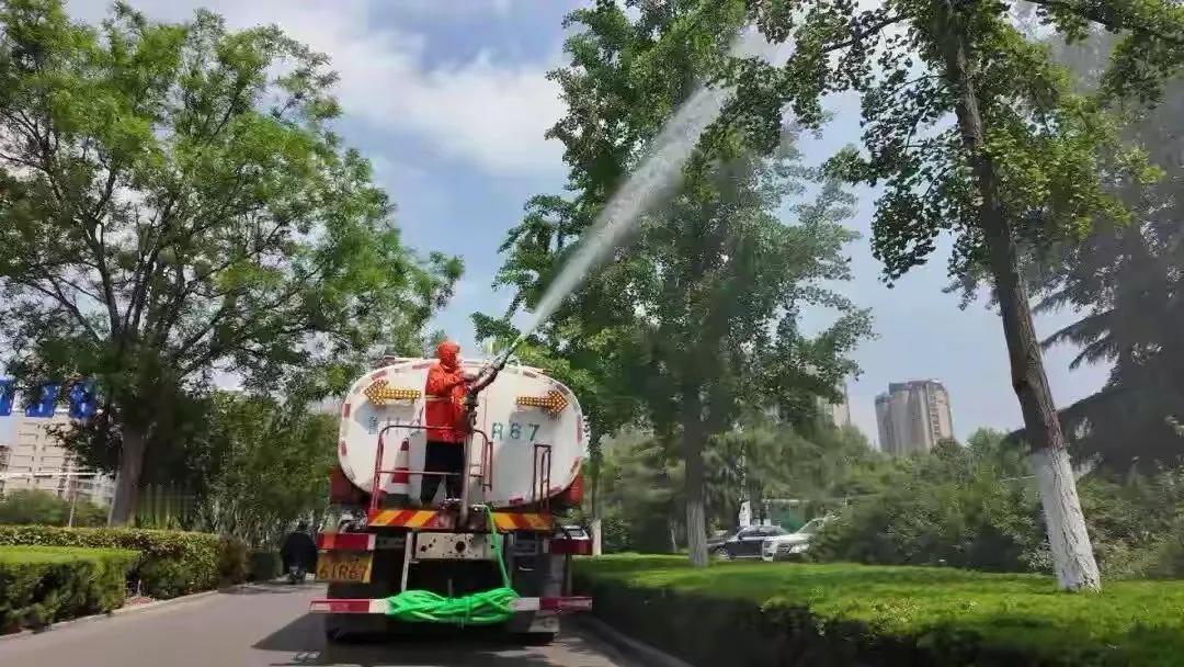 山东济宁，一溜多辆雾炮车、洒水车沿着公路缓慢行驶，边开边用水喷淋树冠，以此来对付