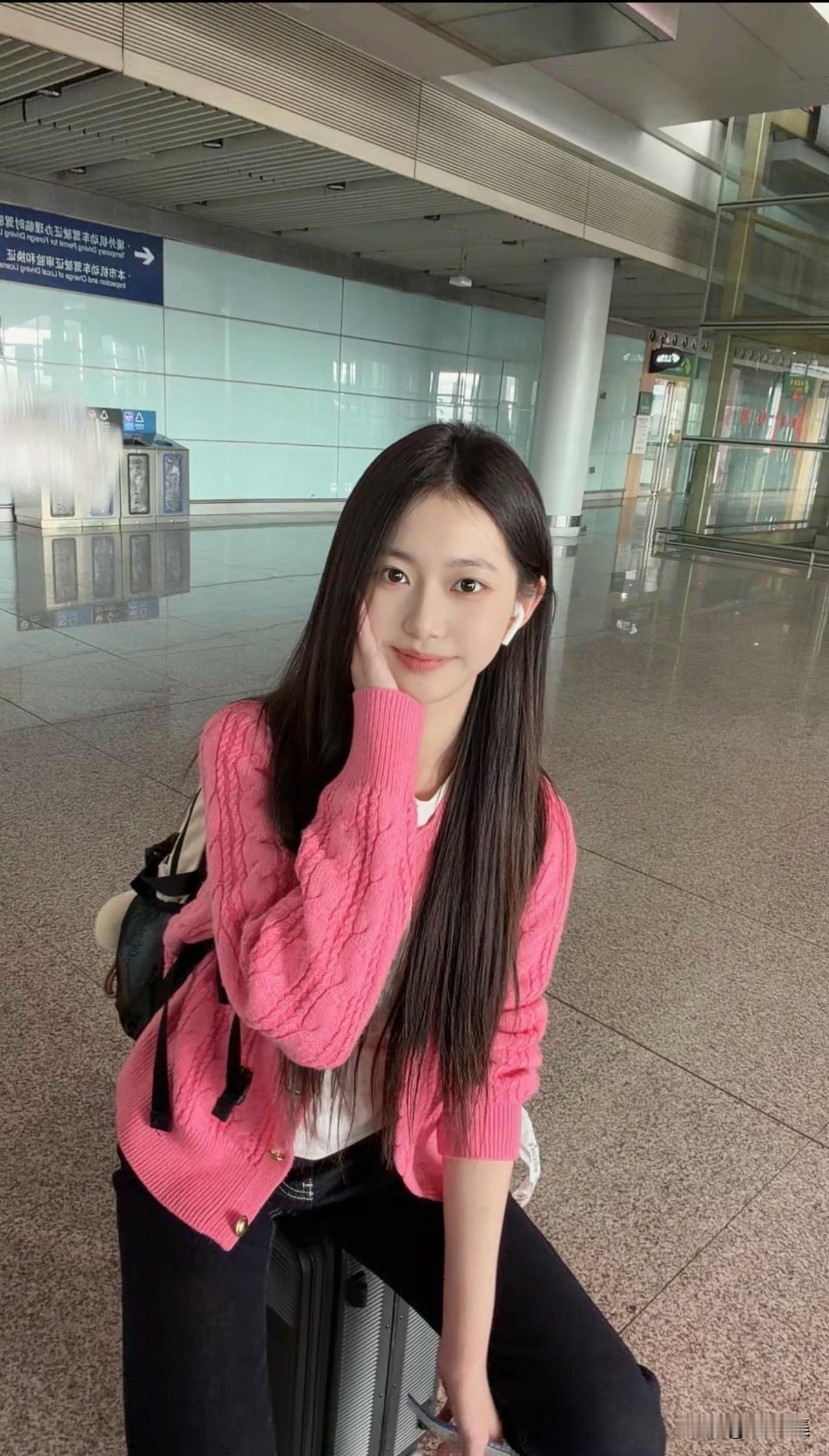 📸 在机场的元气少女，粉色的毛衣和微笑，完美搭配！