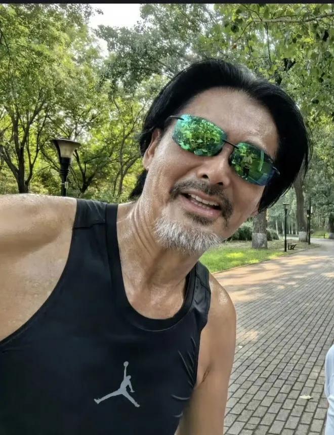 周润发在朝阳公园晨跑，黑色背心加运动裤状态真不错，如果不留白色的胡须，根本看不出