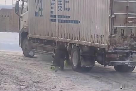 1月18日，新疆博尔塔拉一交警脱下大衣，垫在货车打滑的车轮下，帮助货车司机前行。