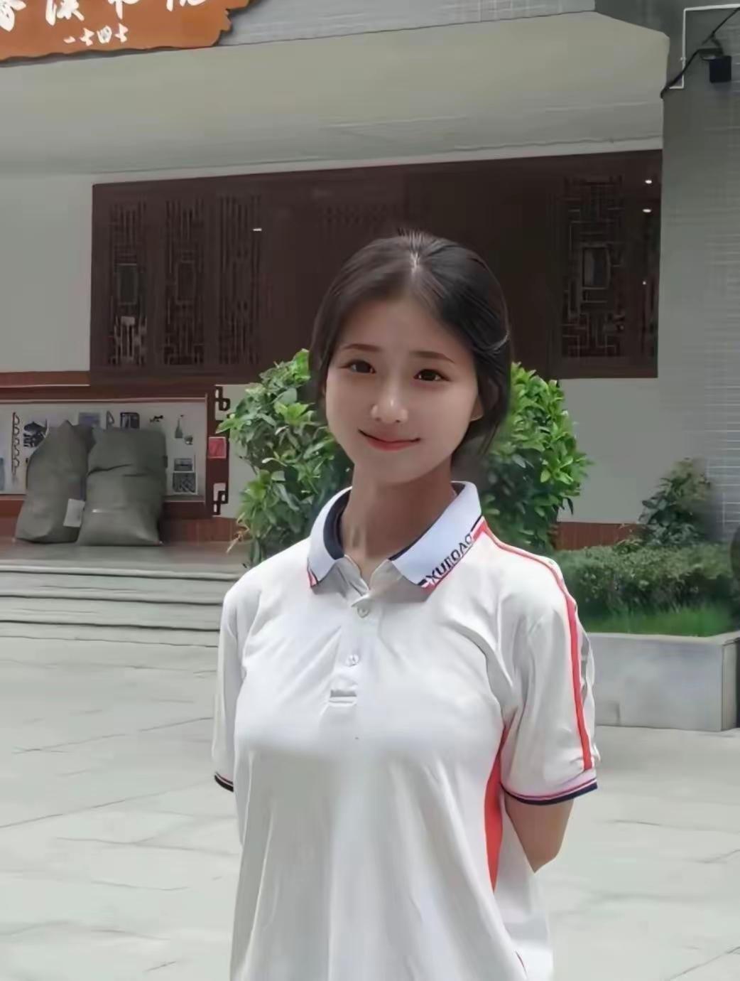 这姑娘穿着白T恤，站在建筑前。