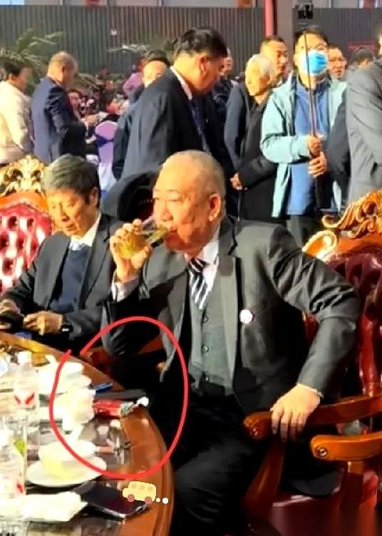 崔培军的年会，一桌子人，镜头就对着他手上。
手指间夹着一根烟，红色的软盒就扔在桌