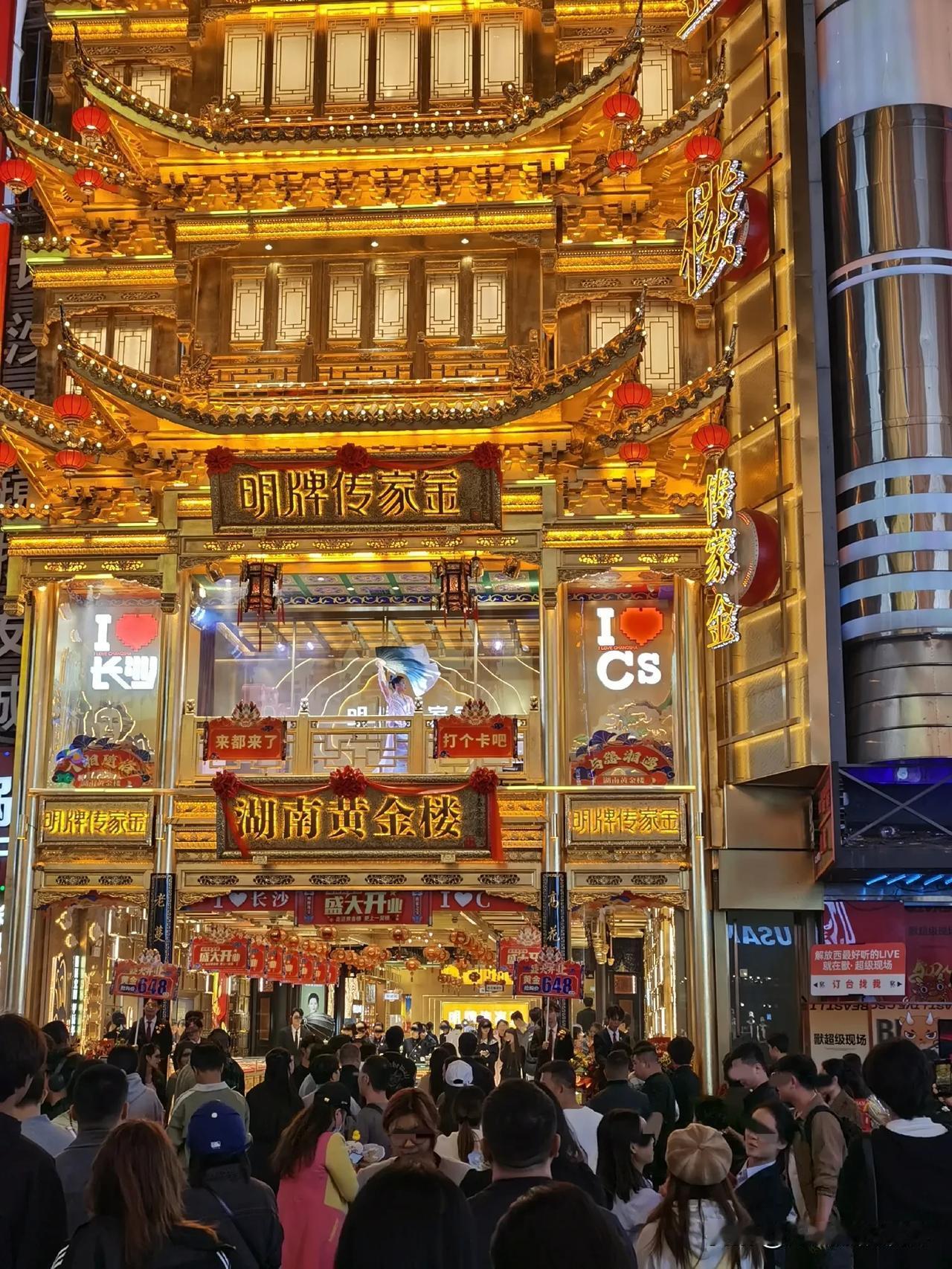 入夜了，长沙的黄金楼是灯火辉煌，楼上表演者像仙子一样飘飘起舞，楼下游客人头攒动。