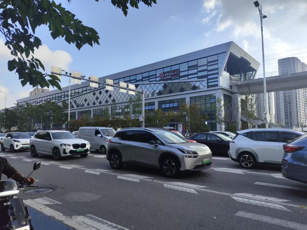你们知道乐清的轻轨有多方便吗？

车流穿梭的路口，远处就是乐清轻轨道交通万岙站。
