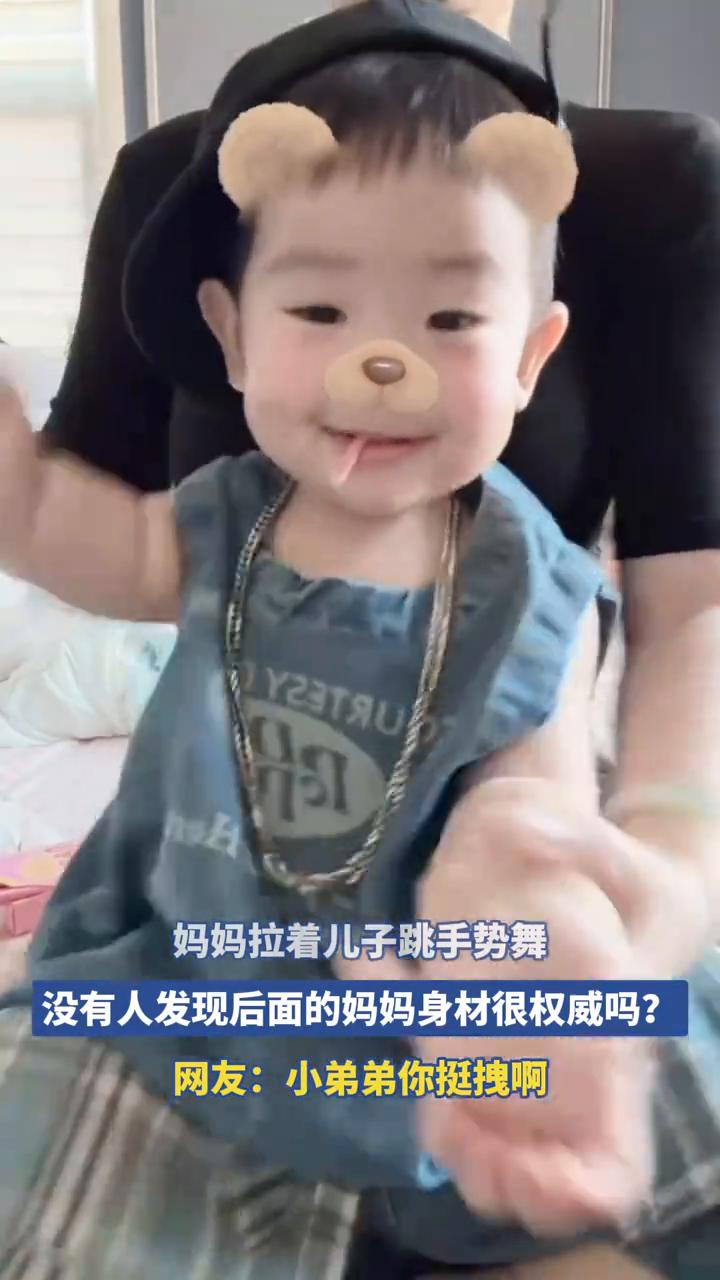 妈妈拉着儿子跳手势舞，没有人发现后面的妈妈身材很权威吗？
网友：小弟弟你挺拽啊。