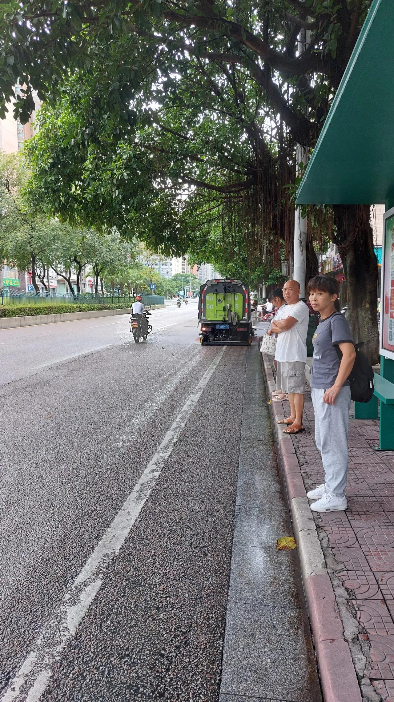 环卫工人的扫地车，扫地时兼顾洒水把道路扫的非常干净了，维护城市环境的环卫工人们辛