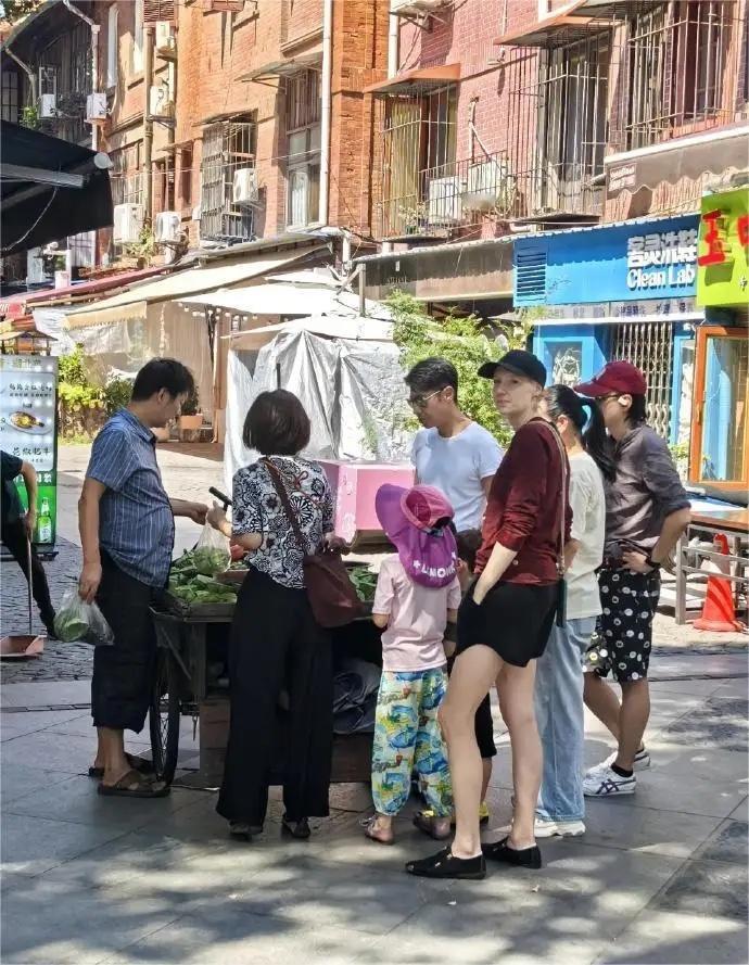撒贝宁夫妇带孩子在武汉逛街，李白的大长腿抢镜，几人在街头买莲蓬，十分接地气 ​​