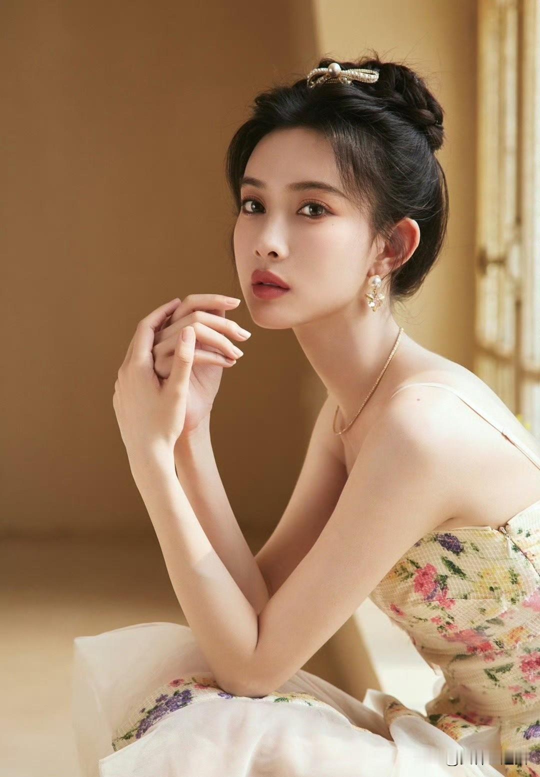 这位姐姐穿着花裙，坐在窗边。