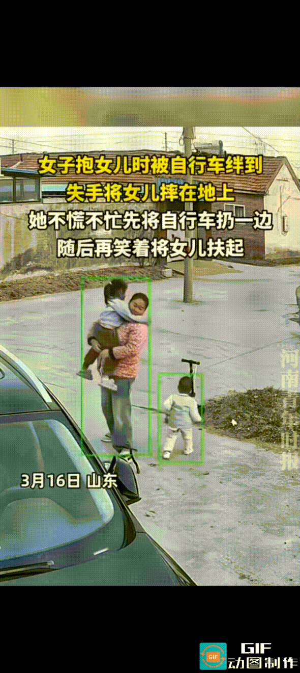 女子抱着女儿走路，没有看到脚下倒着一辆儿童小单车，迈步时被小单车绊了一下，怀中的