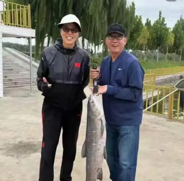 65岁郎平从美国低调回京，被网友偶遇与丈夫王育成在湖边悠然垂钓。照片里，郎导一身