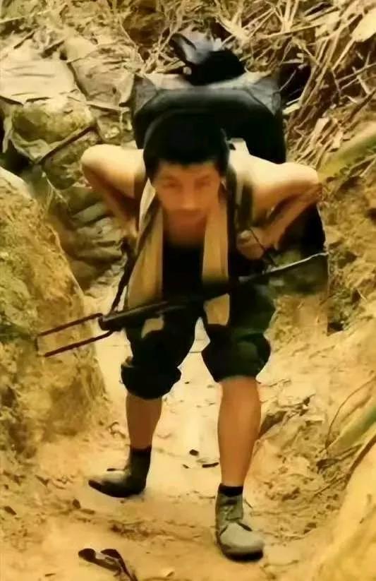 这张照片拍摄于 1987 年的老山前线，一名军工战士正在往前沿阵地运送物资。​