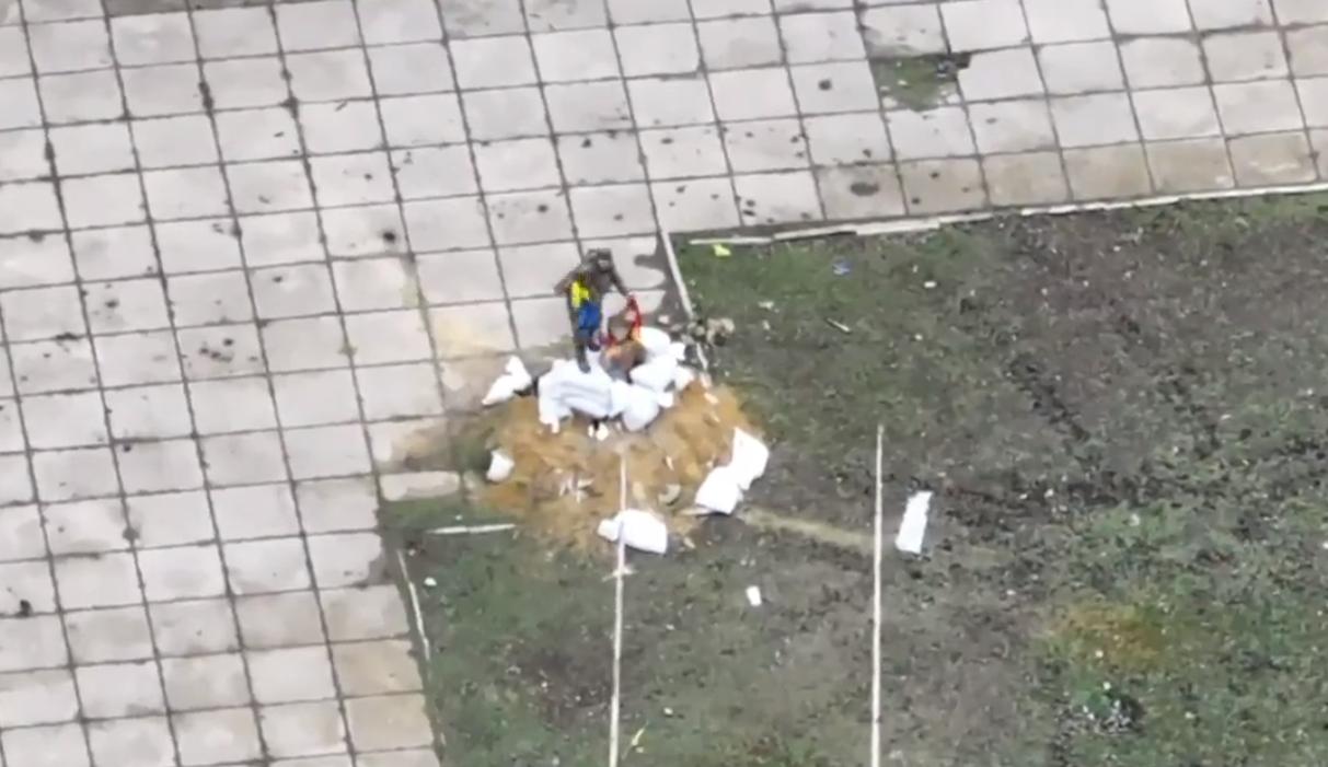 在胡利亚伊波列市中心，一名俄罗斯士兵正在将第57旅的旗帜披在涅斯托尔·马赫诺的雕