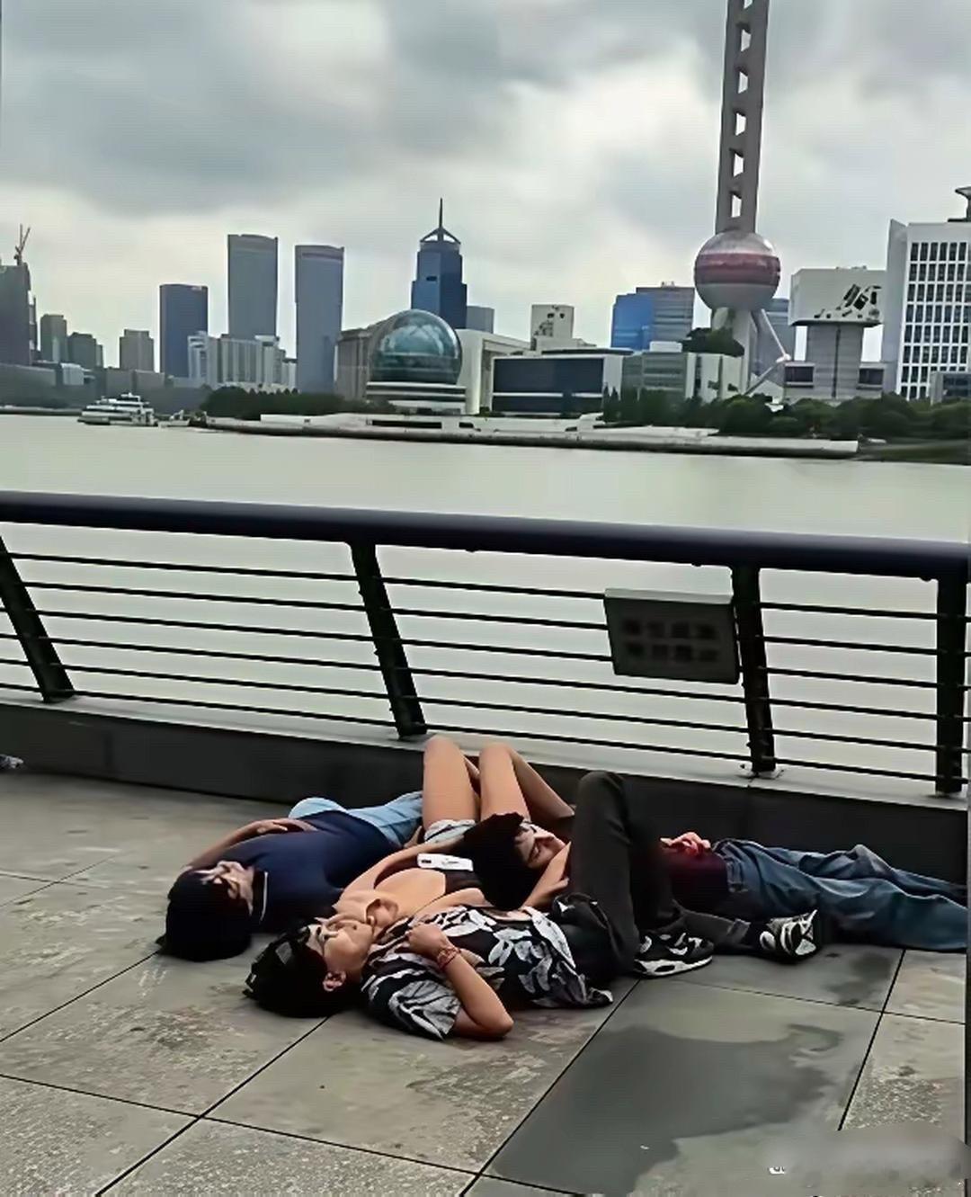 印度游客在上海外滩随地躺着吹江风，看着都很轻松惬意嘛。 