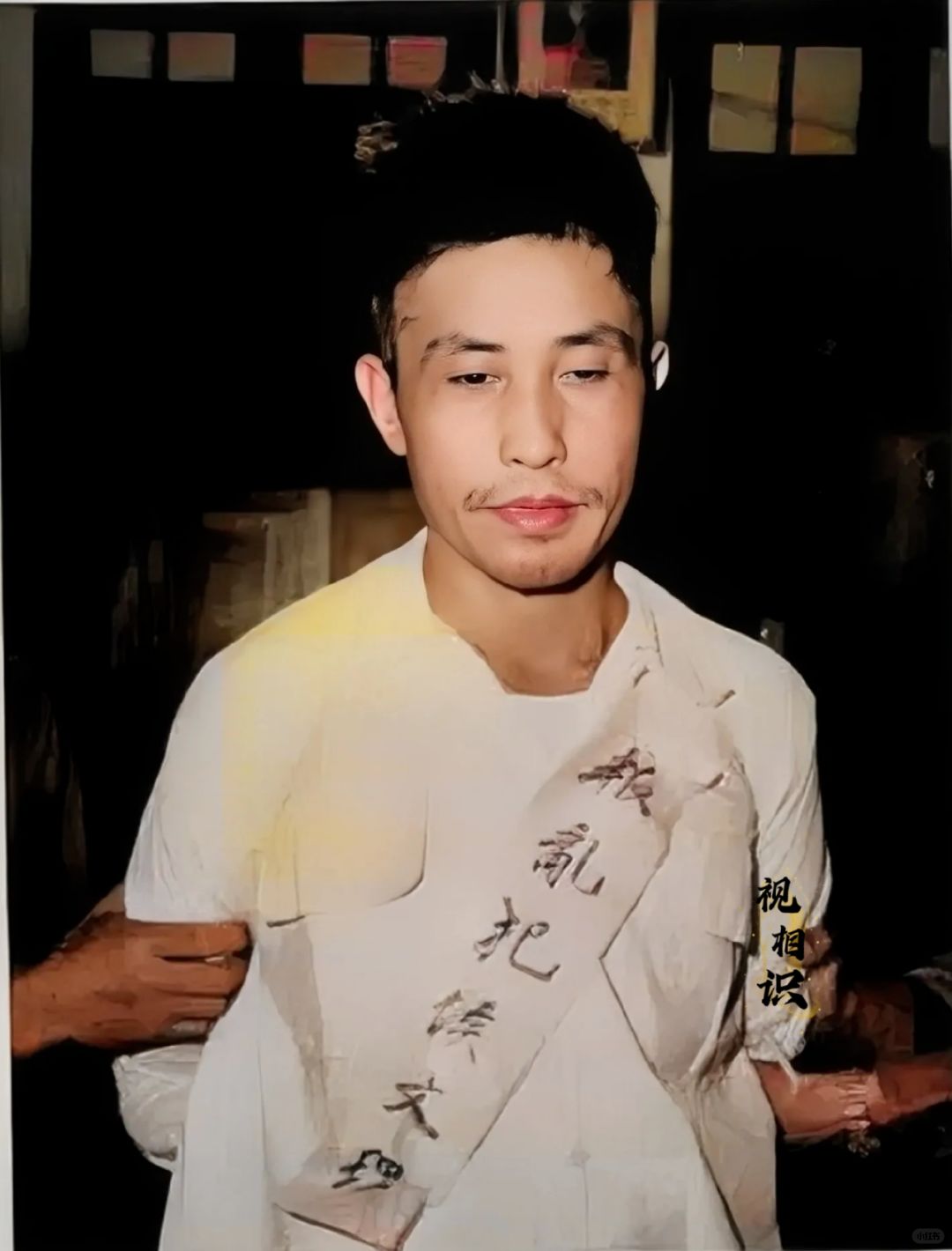 1958年，台北刑场，侯文理烈士英勇就义前的场景，镜头中他身穿白色衬衣，胸前纸上...