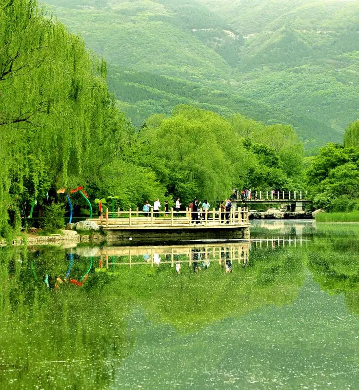 上联：日照青山翠，
下联：风吹绿柳柔。