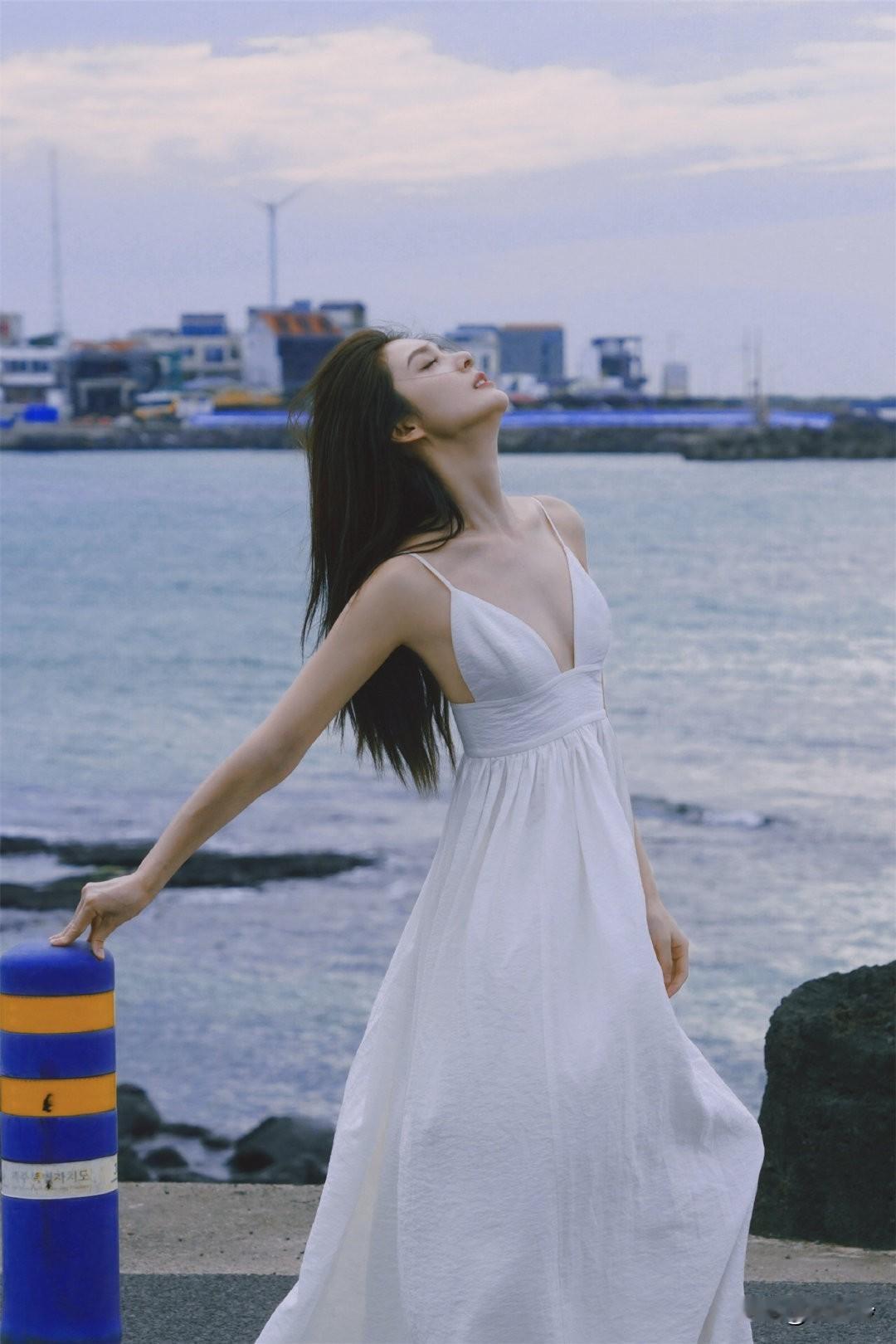 一位姑娘在海边仰望天空，好美！