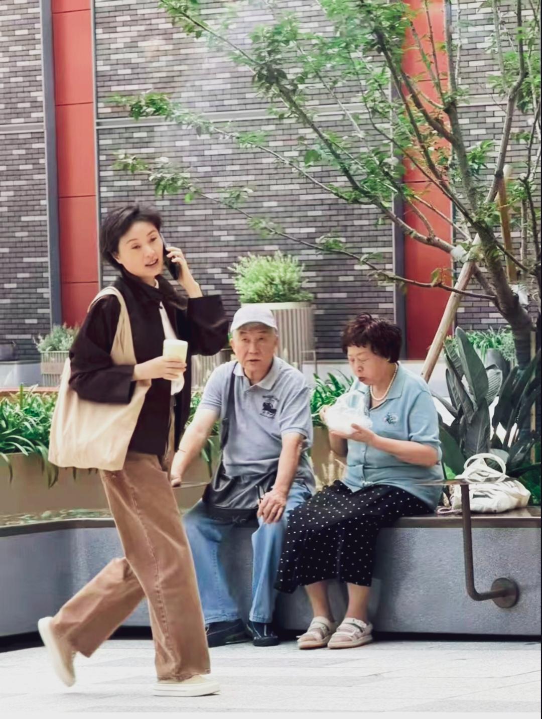 吴越老师一边打电话一边匆匆走过，身材苗条皮肤白皙，休闲穿搭，特显年轻！
