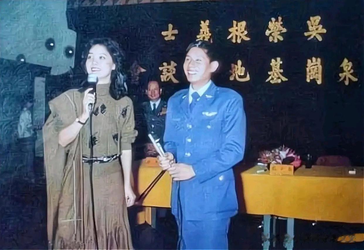 照片中与邓丽君同台演唱的是一名叛逃到台湾的解放军飞行员。
他叫吴荣根，本是解放军