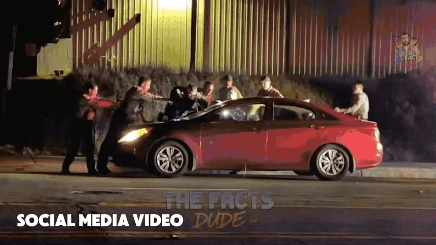 美国街头警察查车的画面，堪比现实版的警匪大片，六名警员手里拿着枪支向这台红色的轿