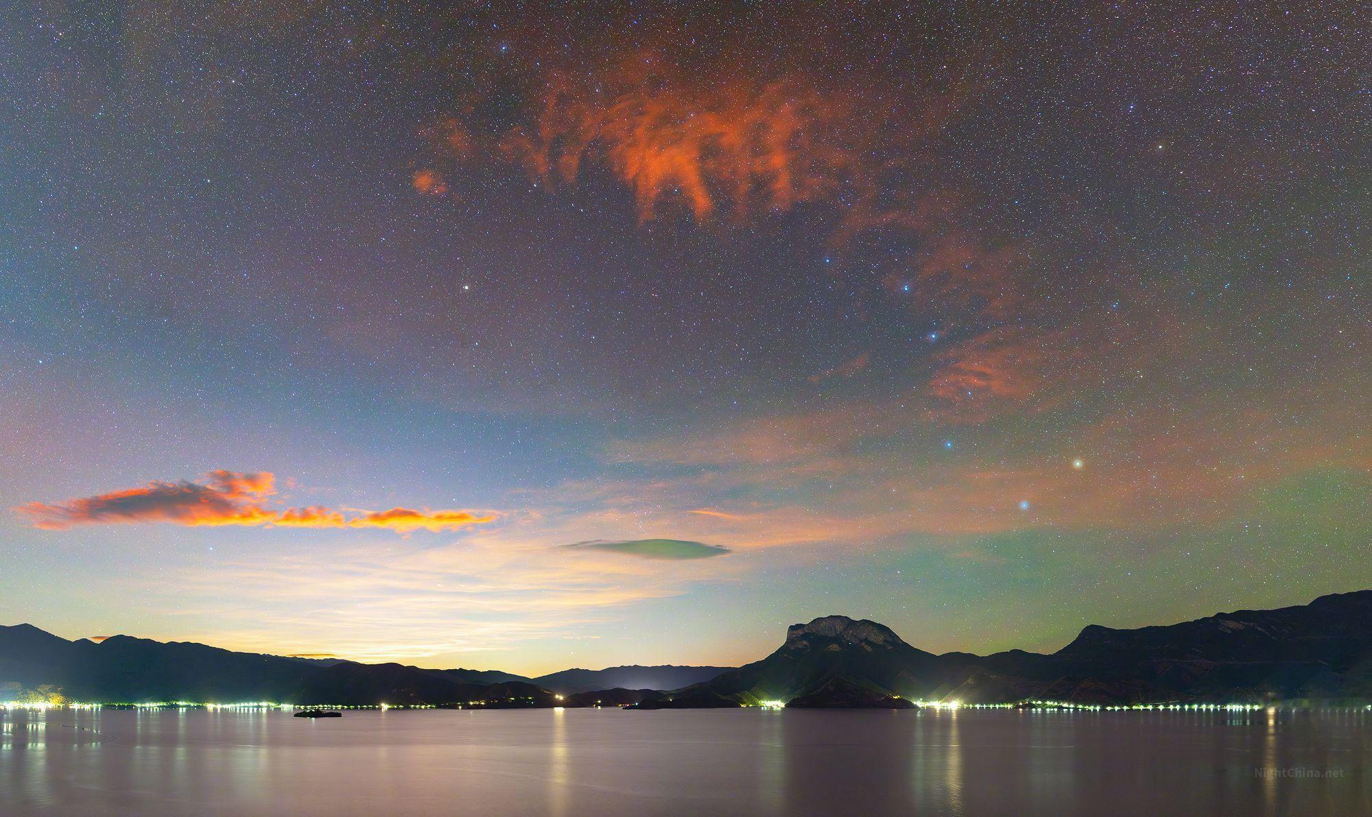 月霞将云层烧成橙红，北斗七星便悬在那片火色之下，在橙红与深蓝之间沉甸甸地低垂着，
