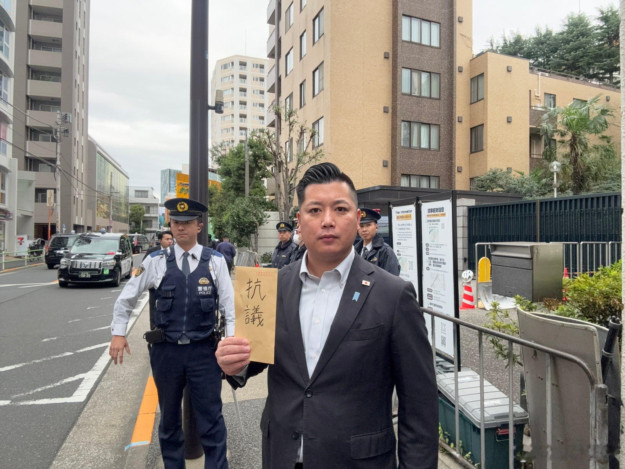 日本松户市一个议员跑到中国大使馆抗议薛剑的发言然后被日本警察围了，只能拿出一个信
