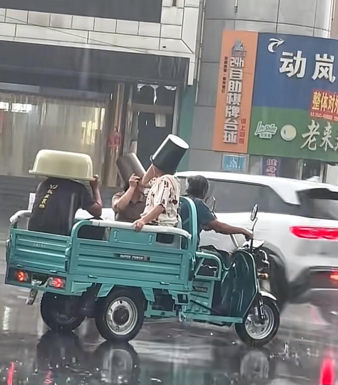 邹平突降大雨，三轮车上盆桶当伞笑翻路人

今天下半晌我在邹平城里溜达，天说变就变