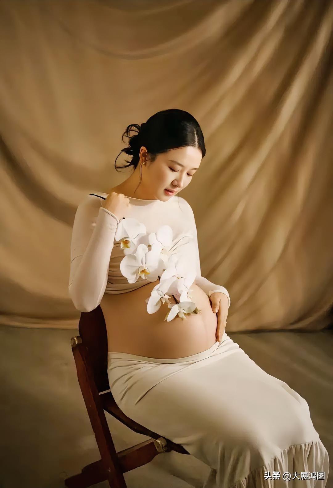 温柔孕味照中，白色长裙与白色兰花相得益彰，将母性之美展现得淋漓尽致。长裙孕妇照 