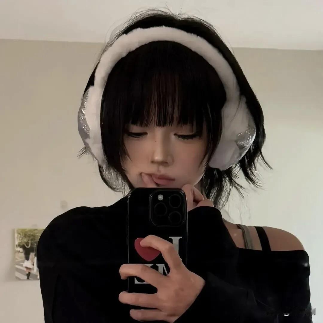 耳机裹着蓬松的白
像把冬日的软云
轻轻别在鬓角的风里
 
她低头吻向屏幕的光
指