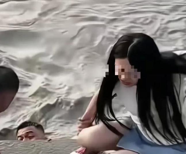 武汉汉口，一女子站在江滩边，丈夫给她拍照，突然丈夫扔下手机，纵身跳入江里。而妻子