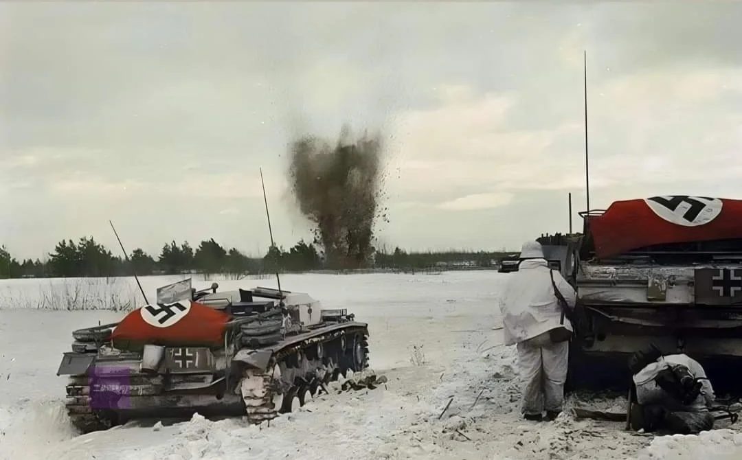 两辆StuG III Ausf. E突击炮向前推进，向敌方阵地开火，同...