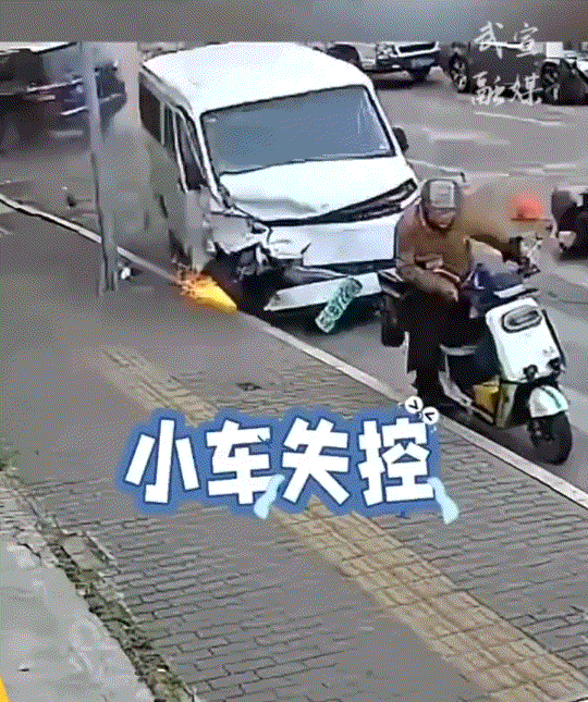 神级反应！一男子骑电动车在路口等红灯时，突然后方一辆小车失控，直接朝着男子撞来。