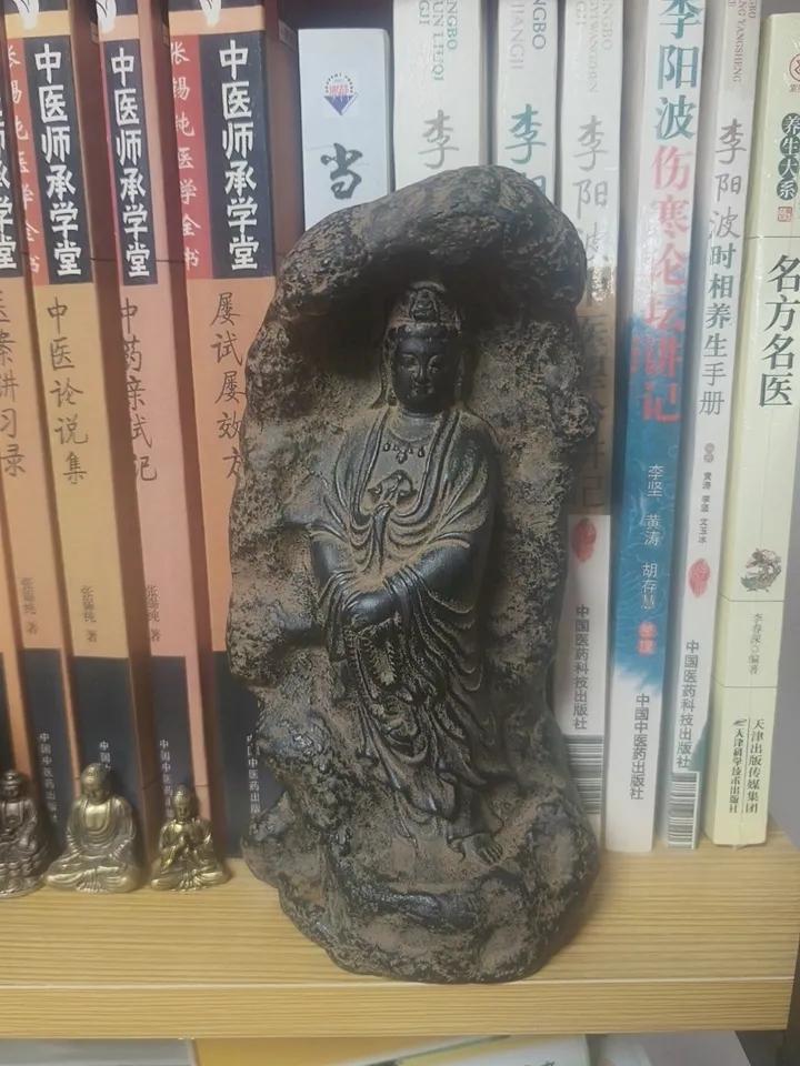 书架上的一尊菩萨像。古朴雅致，这是读书前的静心时刻。