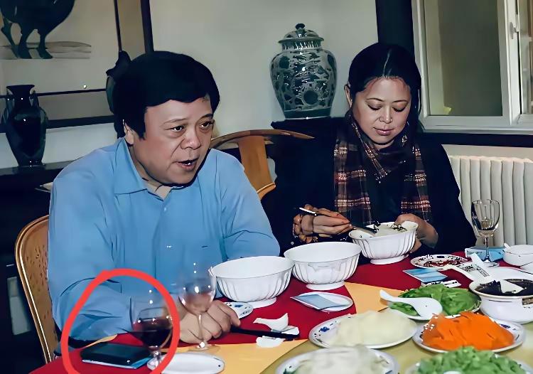 一张年代满满的旧照，镜头里是赵忠祥早年的画面，手里拿着一款复古老手机。
机型古朴
