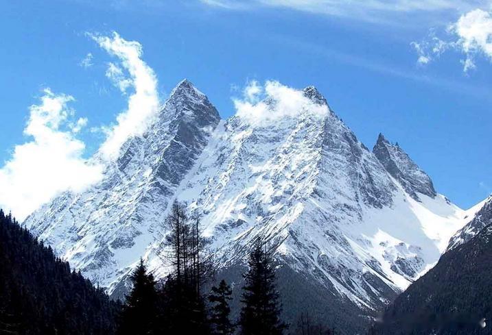 【四姑娘山】四姑娘山山体陡峭，直指蓝天，冰雪覆盖，银光照人。如同头披白纱、姿容俊