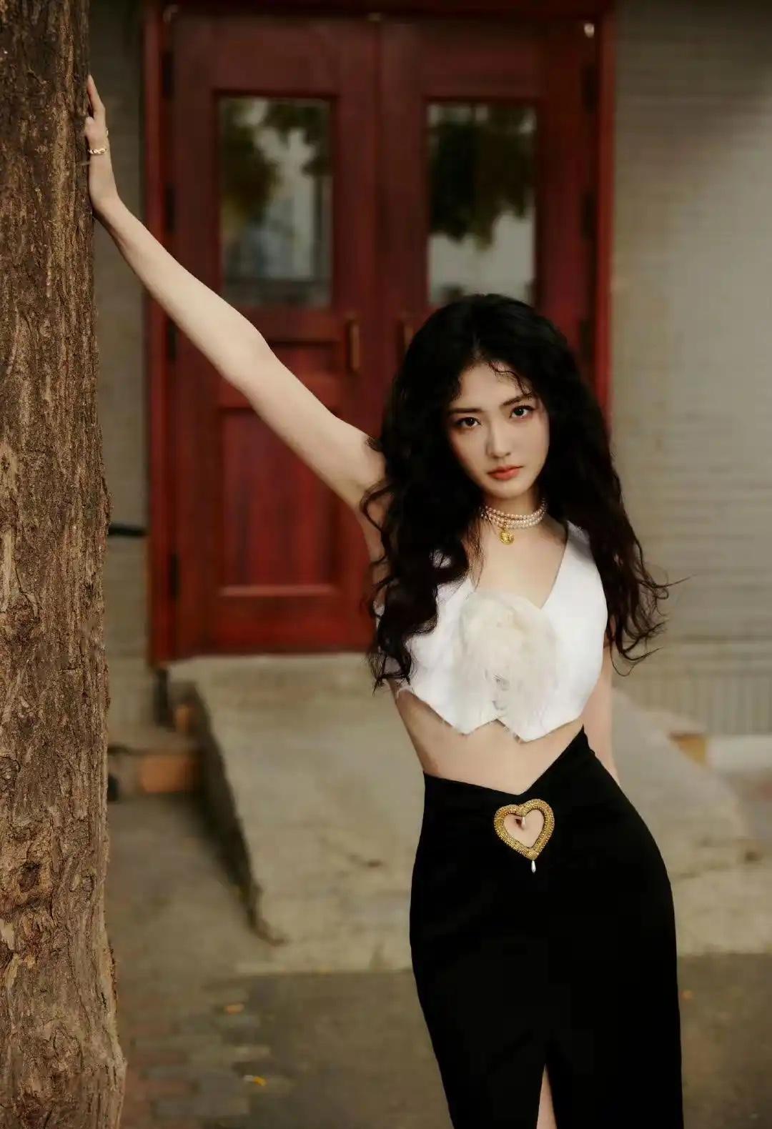徐璐这波羊毛卷真杀疯了。
不靠滤镜，不靠穿搭堆料，一件白背心+黑短裙，腰细得像捏