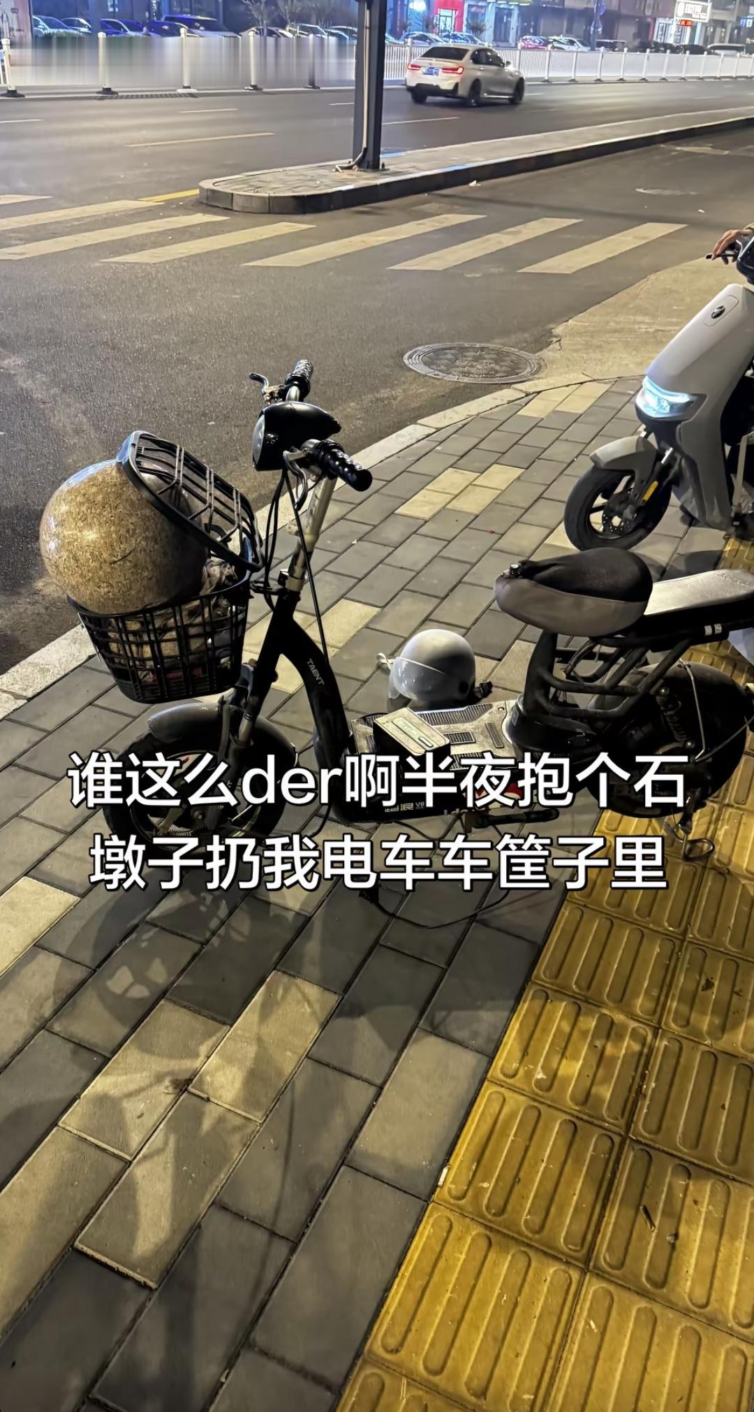 果然，人在做坏事的时候是不怕累的，这不知道哪个闲人把一个石墩子给放在这个电动两轮