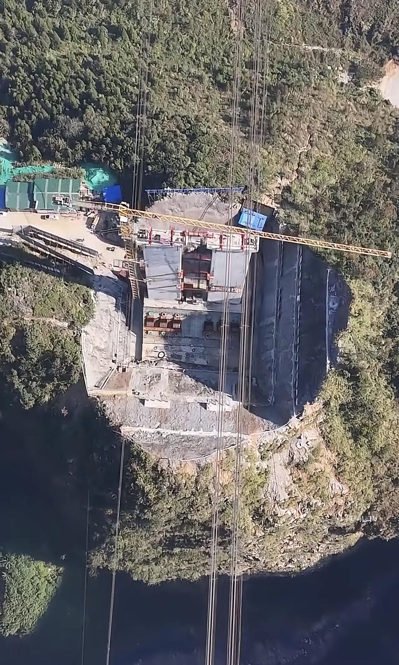 这是花江峡谷大桥建设阶段的高空航拍画面，该桥是贵州六枝至安龙高速公路的关键控制性