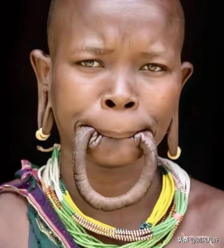 这是一名漂亮的非洲“唇盘族”女孩，她嘴里含着的并不是香肠，而是自己的下嘴唇，女孩