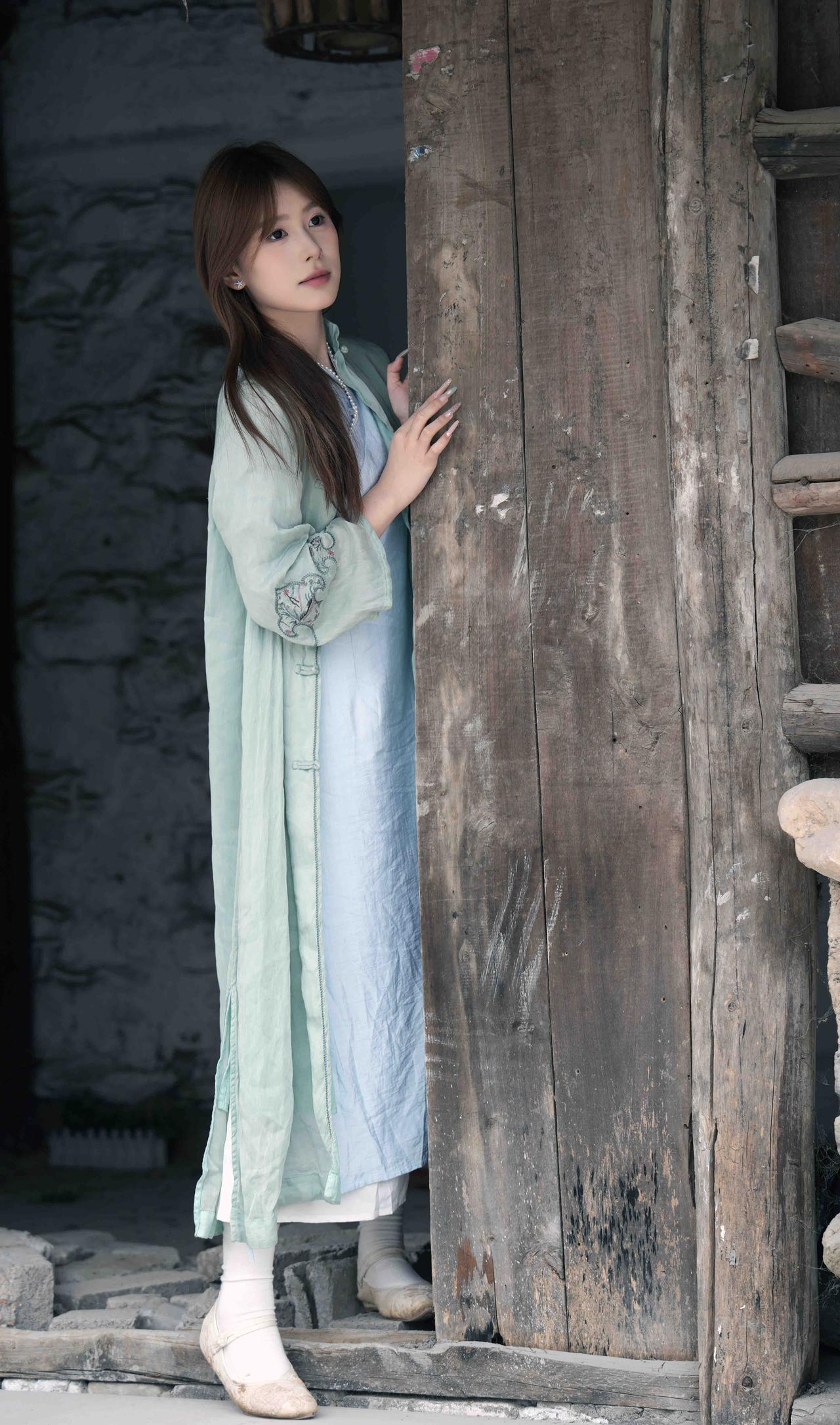 古风少女倚木门，静谧时光如画卷。