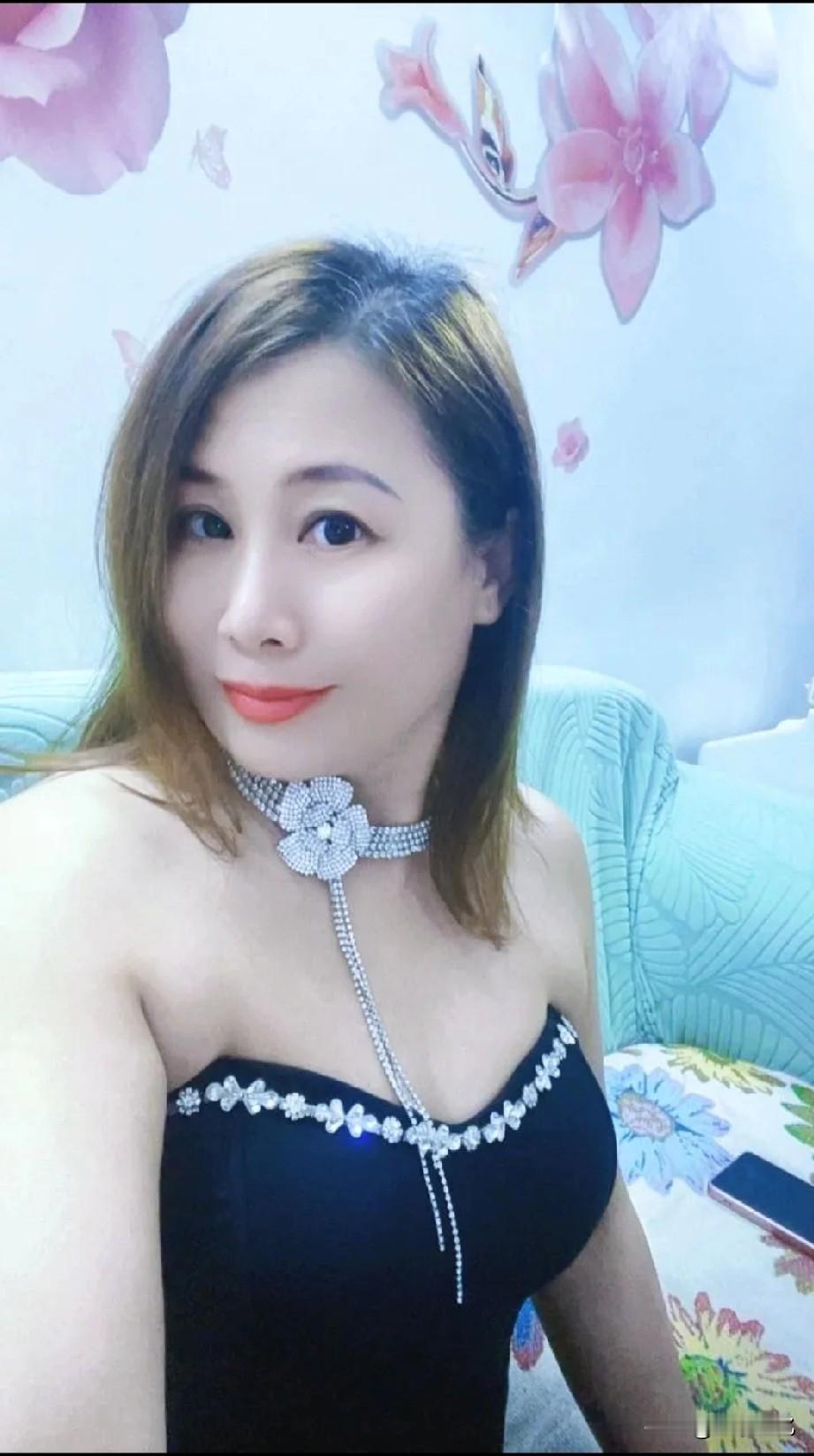 气质优雅，尽显成熟女性的独特魅力。 
她身着黑色抹胸，简约款式勾勒出优美肩颈线条