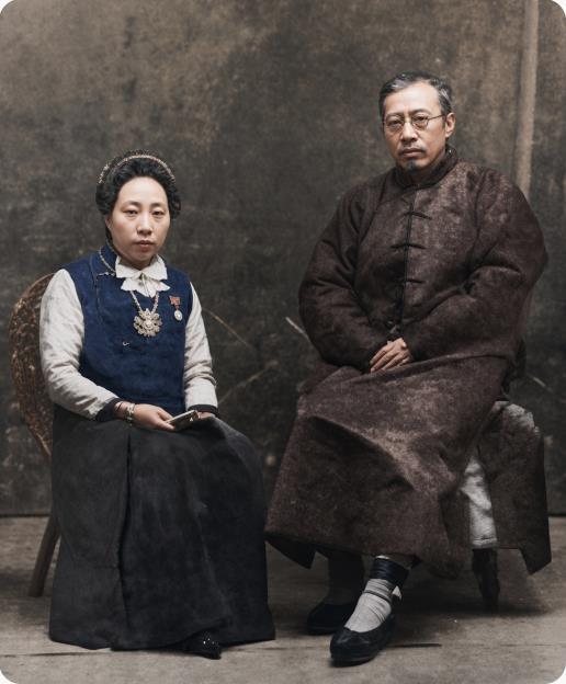 晚清思想巨擘严复与继夫人朱明丽的日常瞬间。
右侧的严复端坐于椅上，身着长袍，头戴