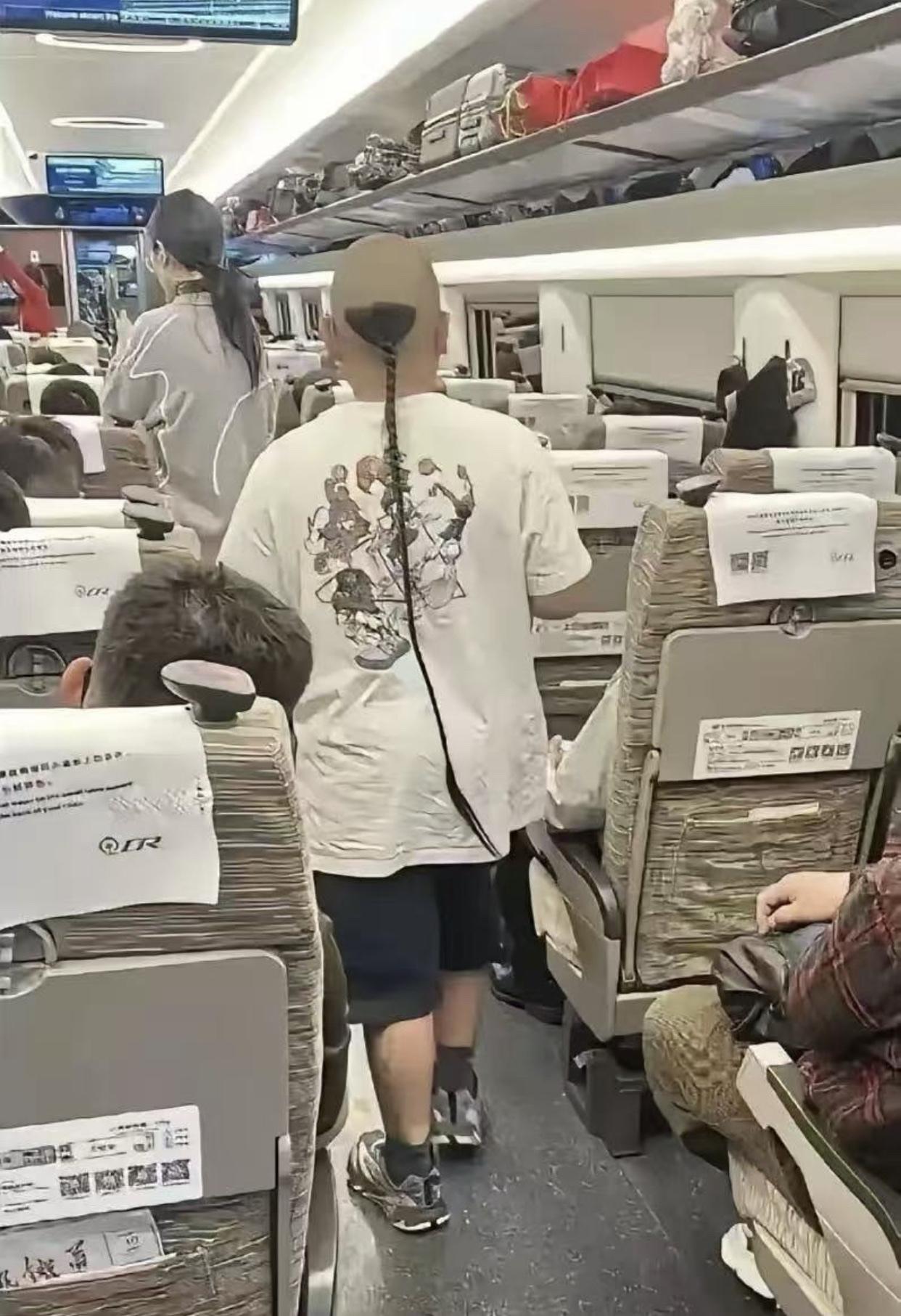 网友在高铁上偶遇留着辫子头的男子，这辫子发型有这么好看吗？这比满清时的辫子头剃的